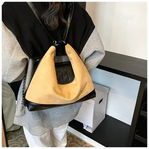 Detail of a large suede tote bag with ginger and black contrast and embossed letters