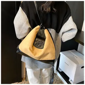 Close-up of matte brown crossbody bag featuring 'CLAPS!' text and chain leather strap