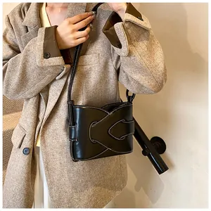 Detail of black crescent shoulder bag with white contrast stitching and crossover design
