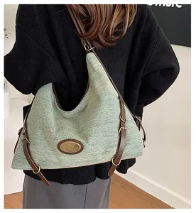 Dettaglio borsa tote in denim verde chiaro con tracolla in pelle e fibbia