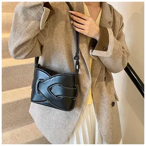 Detail of minimalist black crescent bag with white contrast stitching and sleek leather strap