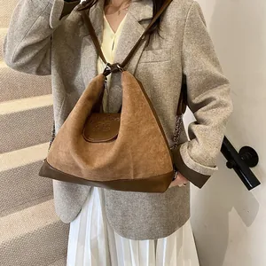 Brown suede and leather tote bag with unique triangular design and chain detail