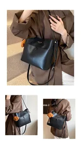 Modische schwarze Beuteltasche mit verstellbarem Riemen und süßem Teddybär-Anhänger Detail