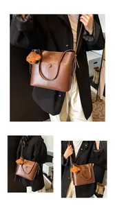 Detailansicht der braunen Leder-Eimertasche mit Fashion-Print und Plüsch-Anhänger
