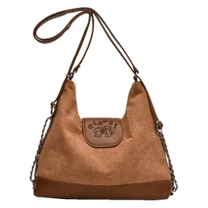 Brown textured suede and leather shoulder bag with bear print and adjustable strap