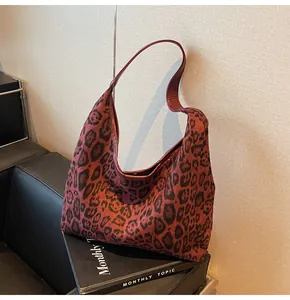 Detail der burgunderroten Hobo-Tasche mit Leopardenmuster und weicher Wildledertextur