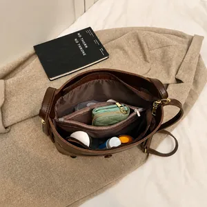 Detailansicht der großen Innenkapazität der dunkelbraunen Eimertasche aus Leder mit Fächern