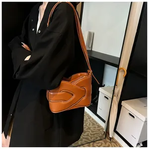 Detail of caramel woven leather shoulder bag with intricate interlaced design