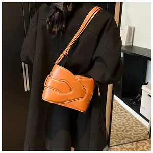 Detail of caramel crescent bag featuring premium lychee texture and woven fold design