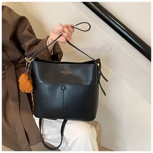 Detail der schwarzen Bucket Bag mit goldener New York Aufschrift und braunem Plüschball