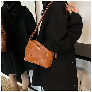 Detailed layered leather design on a brown crescent shoulder bag with neat stitching