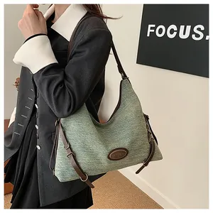 Dettaglio della borsa hobo verde con tracolla in pelle marrone scuro e fibbia in metallo