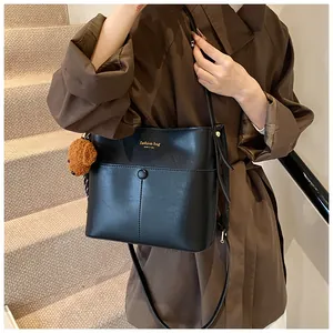 Modische schwarze Beuteltasche mit Braunbär-Anhänger und New York-Aufdruck