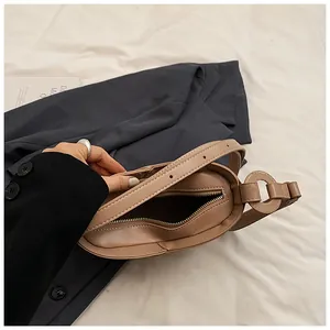Detail of adjustable strap and metal ring hardware on crescent shoulder bag