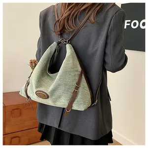 Dettaglio della borsa a tracolla in tessuto verde con finiture in pelle e fibbia vintage