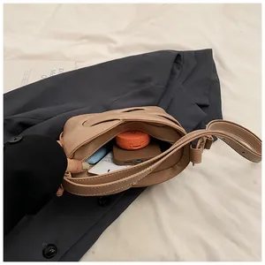 Interior view of beige crescent bag showing capacity for phone, cards and makeup products