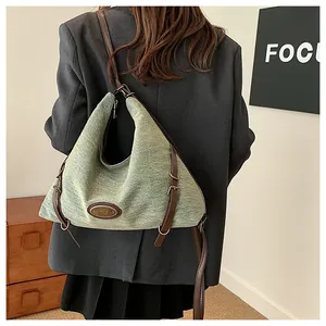 Dettaglio della borsa hobo verde chiaro con cinturini in pelle marrone e fibbie metalliche