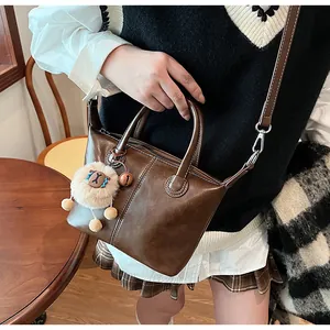 Detail of brown vintage PU tote featuring contrast stitching and cute lamb plush charm