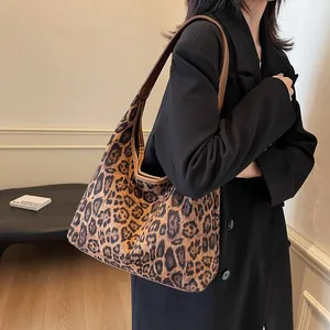 Retro-Leoparden-Tragetasche mit braunen Lederriemen, getragen von einem Modell im Blazer