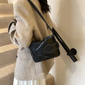 Minimalist black crescent shoulder bag with white contrast stitching on crossbody strap
