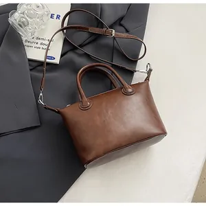 Close-up of brown leather tote bag with silver hardware and adjustable shoulder strap