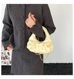 Detail of off-white pleated crescent bag with sparkling rhinestones and gold chain