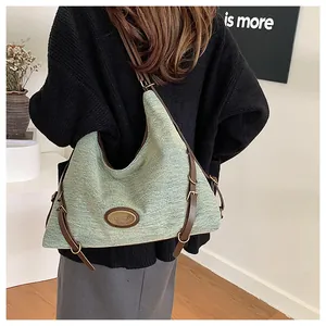 Dettaglio della borsa tote in tessuto verde chiaro con spalline in pelle marrone e metallo