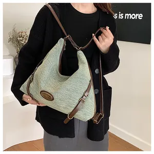 Dettaglio borsa tote in tweed verde chiaro con cinturini in pelle marrone e fibbia ovale