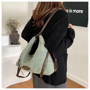 Dettaglio degli spallacci in pelle regolabili e della trama del tessuto verde vintage