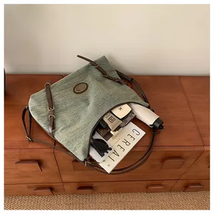 Vista dall'alto della borsa tote in denim con ampio spazio interno e accessori vari
