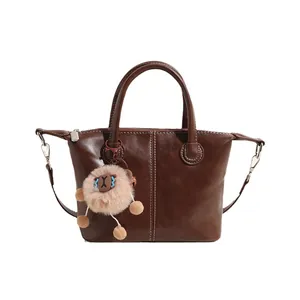 Brown faux leather tote bag with dual handles and cute plush alpaca charm accessory