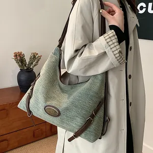 Borsa tote in denim intrecciato blu con finiture in pelle marrone e tracolla regolabile