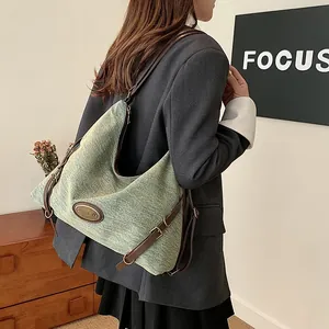 Borsa tote in denim verde chiaro con cinturini in pelle marrone e fibbia in metallo laterale