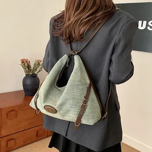 Zaino in tessuto strutturato verde con spallacci in pelle e logo metallico laterale