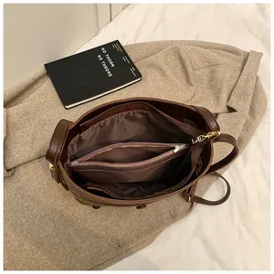 Detailansicht der Innenfächer und des goldenen Reißverschlusses der braunen Tasche