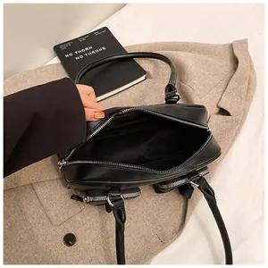 Top view of spacious interior and silver zipper details of a black minimalist shoulder bag
