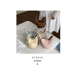Close-up of minimalist bucket bags with knotted handles in various soft pastel colors
