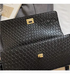 Dettaglio borsa a mano nera intrecciata con chiusura dorata e ampio scomparto interno