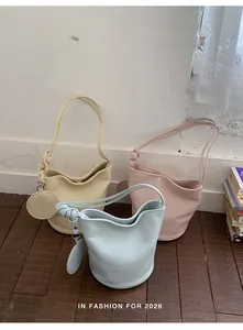 Detailed view of three Morandi-colored bucket bags with knotted straps and coin purses