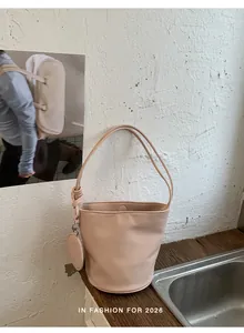 Macro detail of pink leather bucket bag texture and round charm accessory
