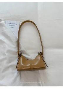 Dettaglio di una borsa hobo vintage marrone con anello metallico argento laterale