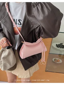 Détail du sac bandoulière vintage rose avec plis froncés et anneaux dorés décoratifs
