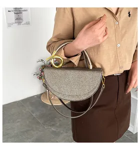 Detail of champagne gold woven handbag with a unique spiral metal buckle and slim strap