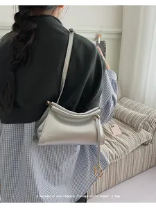 Détail d'un sac à bandoulière vintage argenté avec texture plissée et boucle dorée