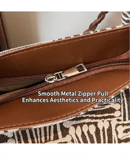 Macro view of silver polished metal zipper puller on large canvas shoulder tote bag