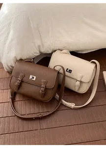Detail view of mini Cambridge crossbody bags in textured brown and cream faux leather