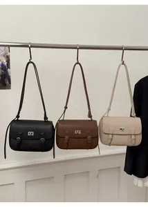 Detail of trendy square messenger bags in black, brown, and beige lychee pattern leather