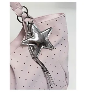 Detail of pink polka dot tote bag with a silver star pendant and premium stitching