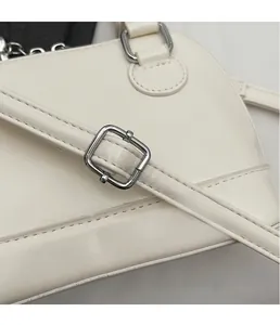 Détail du sac coquillage en cuir blanc montrant la boucle argentée et les coutures