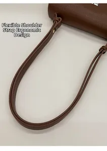 Detail of ergonomic wide knotted shoulder strap on brown lychee texture leather bag
